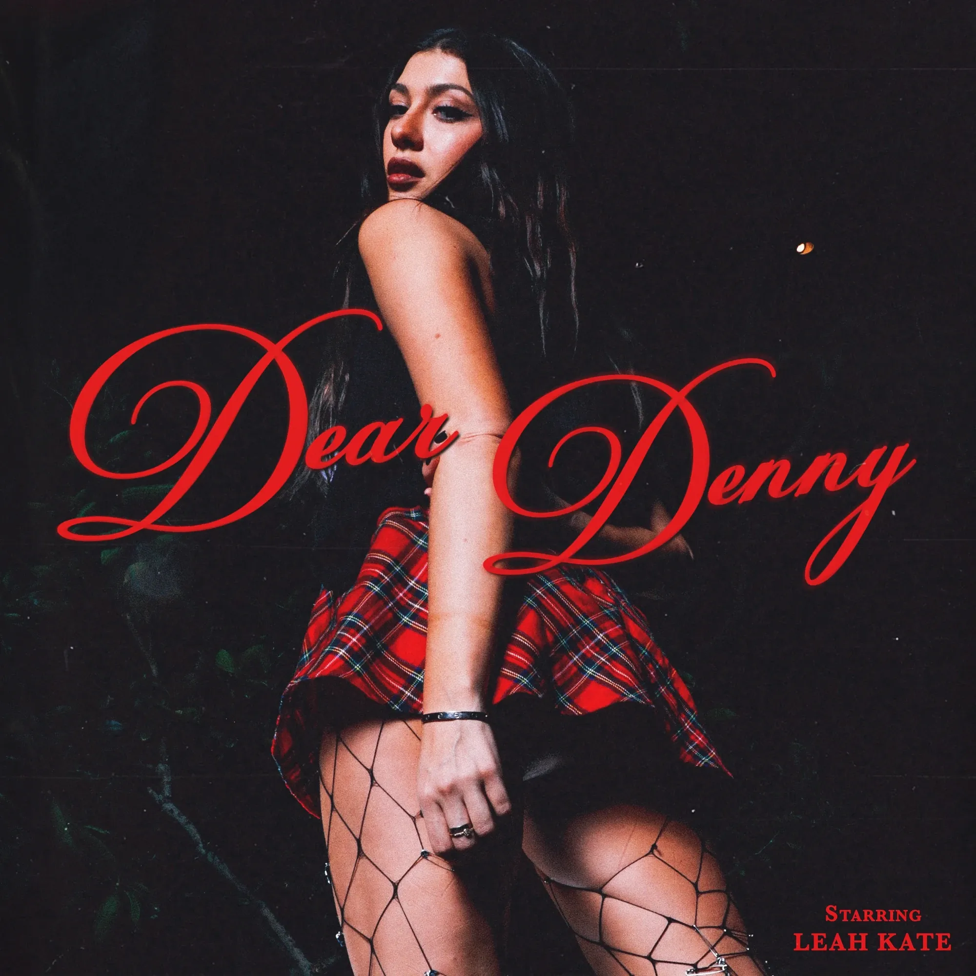 Dear Denny — near black, on-camera flash, red tartan and fishnets, the title in a glossy red script with Starring Leah Kate beneath it
