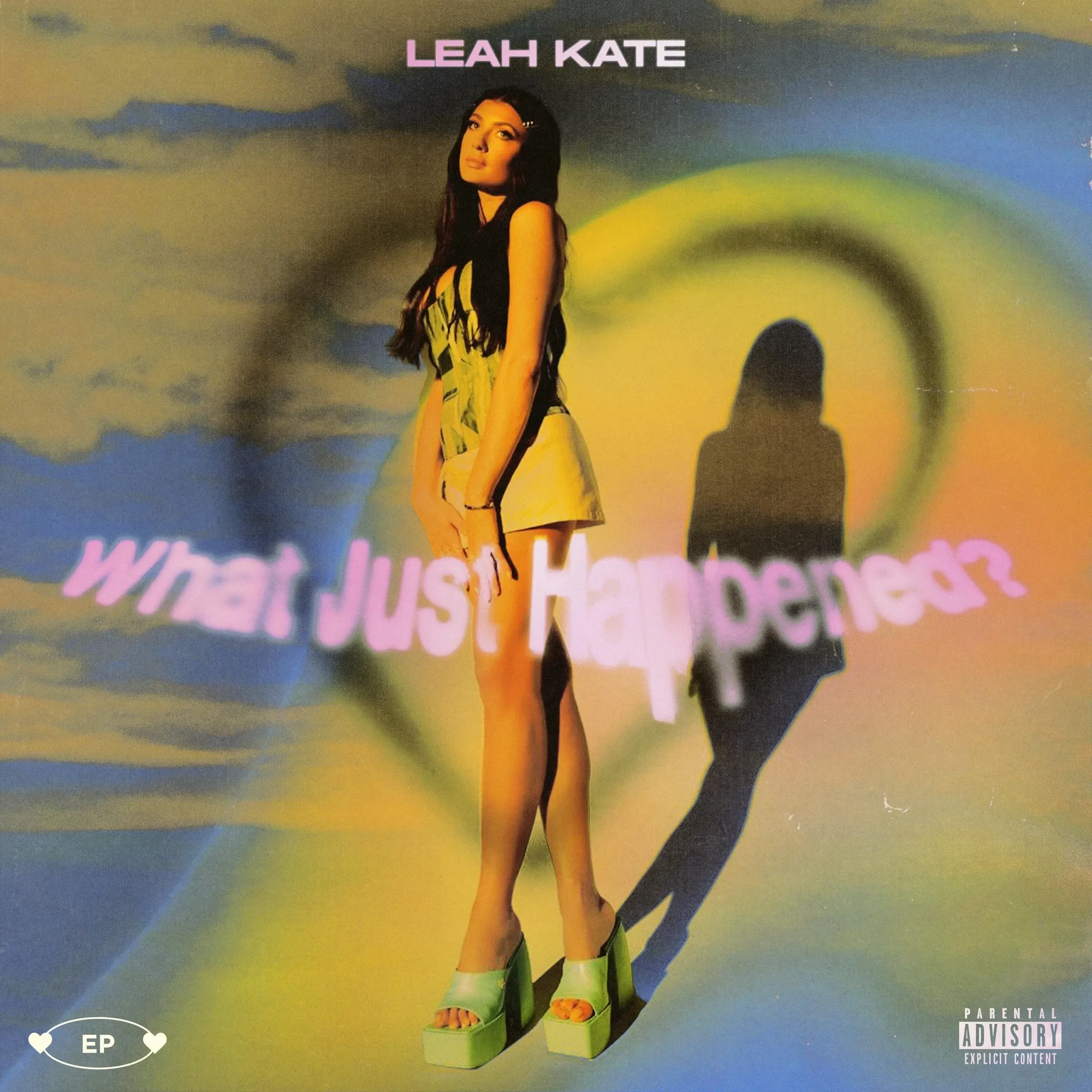 What Just Happened? — an airbrushed sky in lilac, peach and teal with a heart drawn into the haze, Leah Kate standing in front of her own long shadow